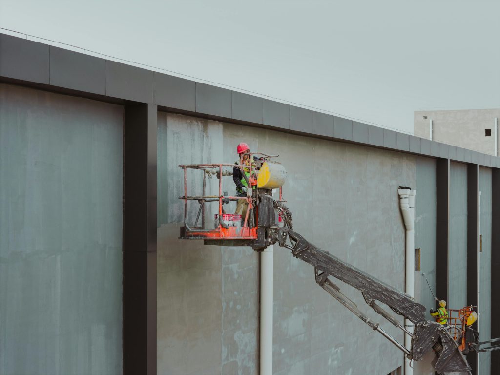 Construction workers using a cherry picker for building maintenance in Huaian, Jiangsu, China.
